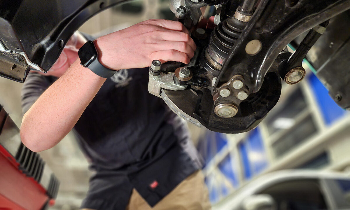 Student Changing Brakes on car