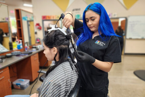 Student curling customer's hair