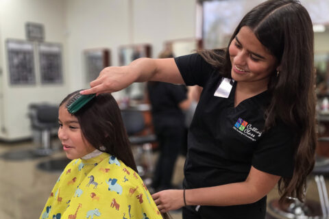 Student brushing customer's hair