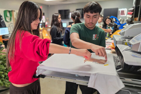 Students heat pressing design onto shirt