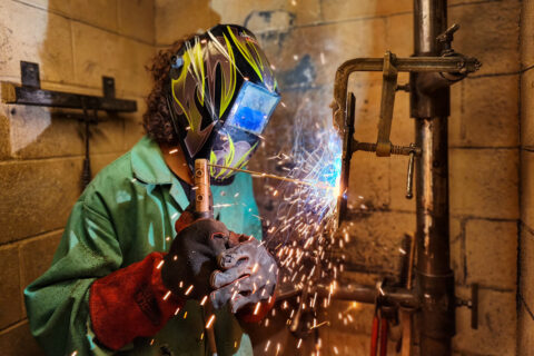 Student welding as sparks fly