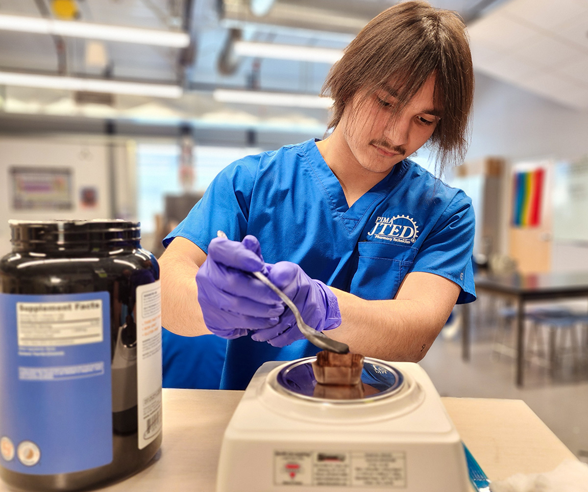 Student measuring powder on scale