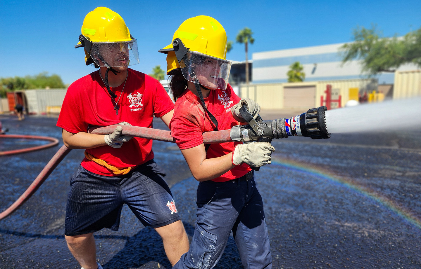 Students aiming fire hose