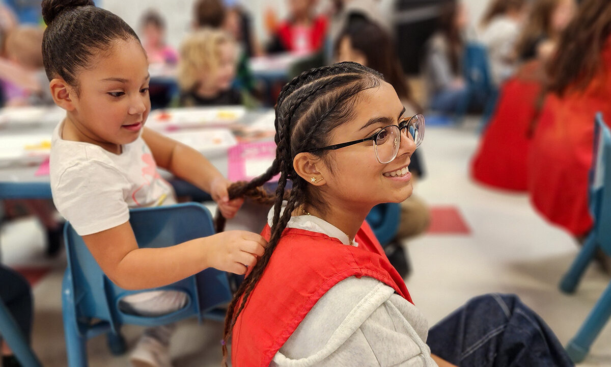 Preschooler playing with student's hair