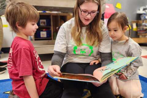 High school student reading to preschoolers