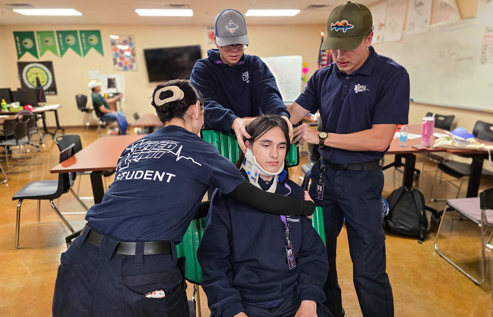 EMT Students stabilizing neck and back in seat