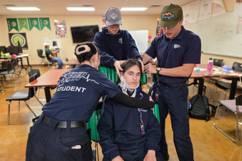 EMT Students stabilizing neck and back in seat