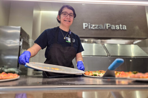 Student removing pizza tray