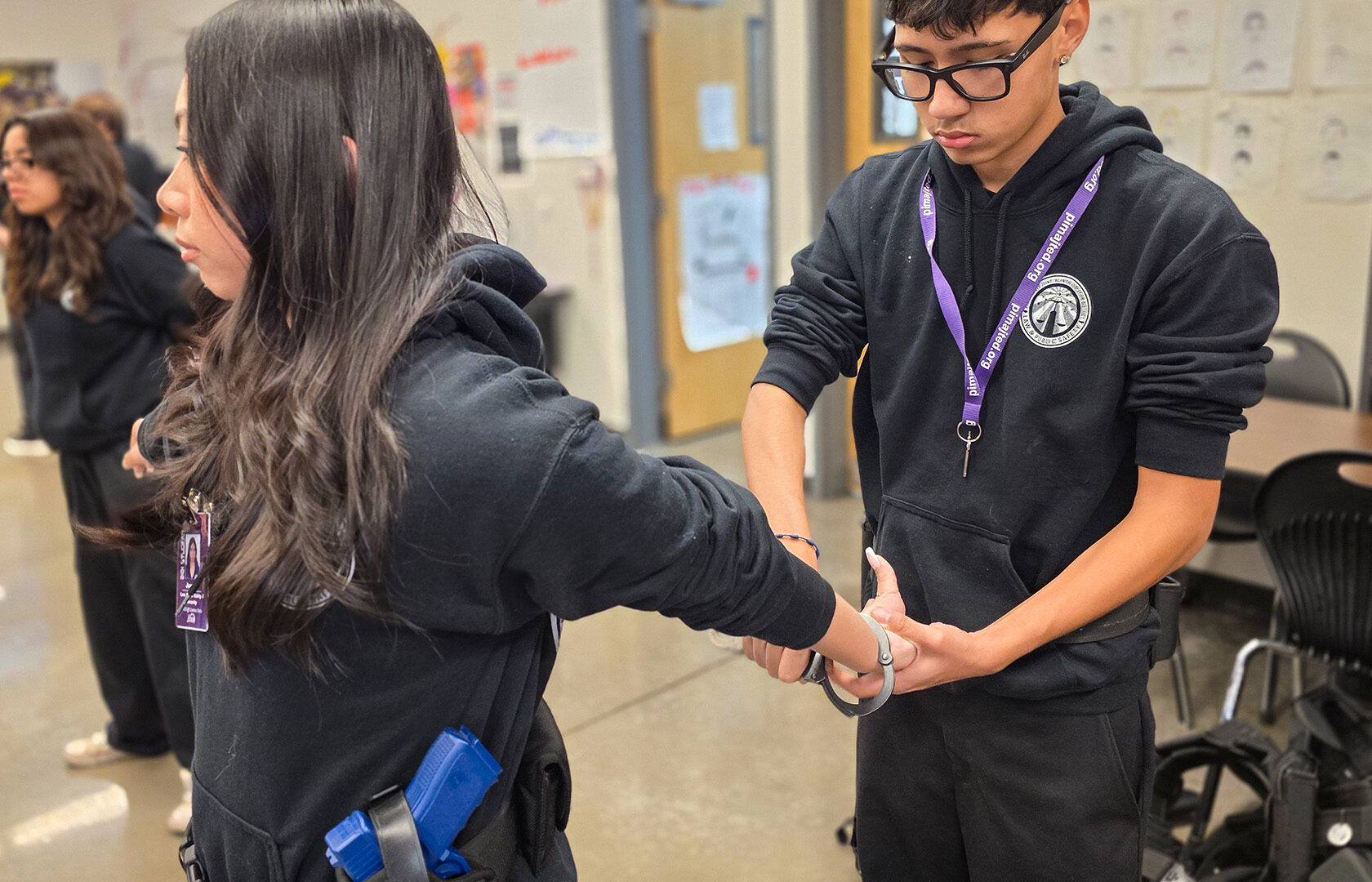 Student applying handcuffs to other student