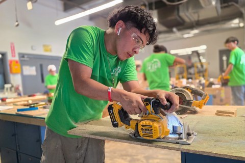 Construction student sawing