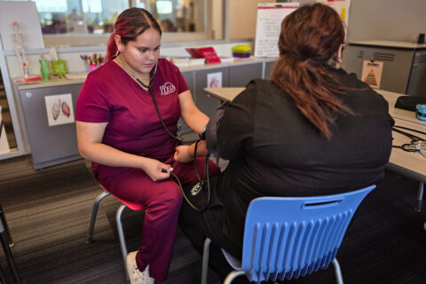 Caregiver student taking blood pressure