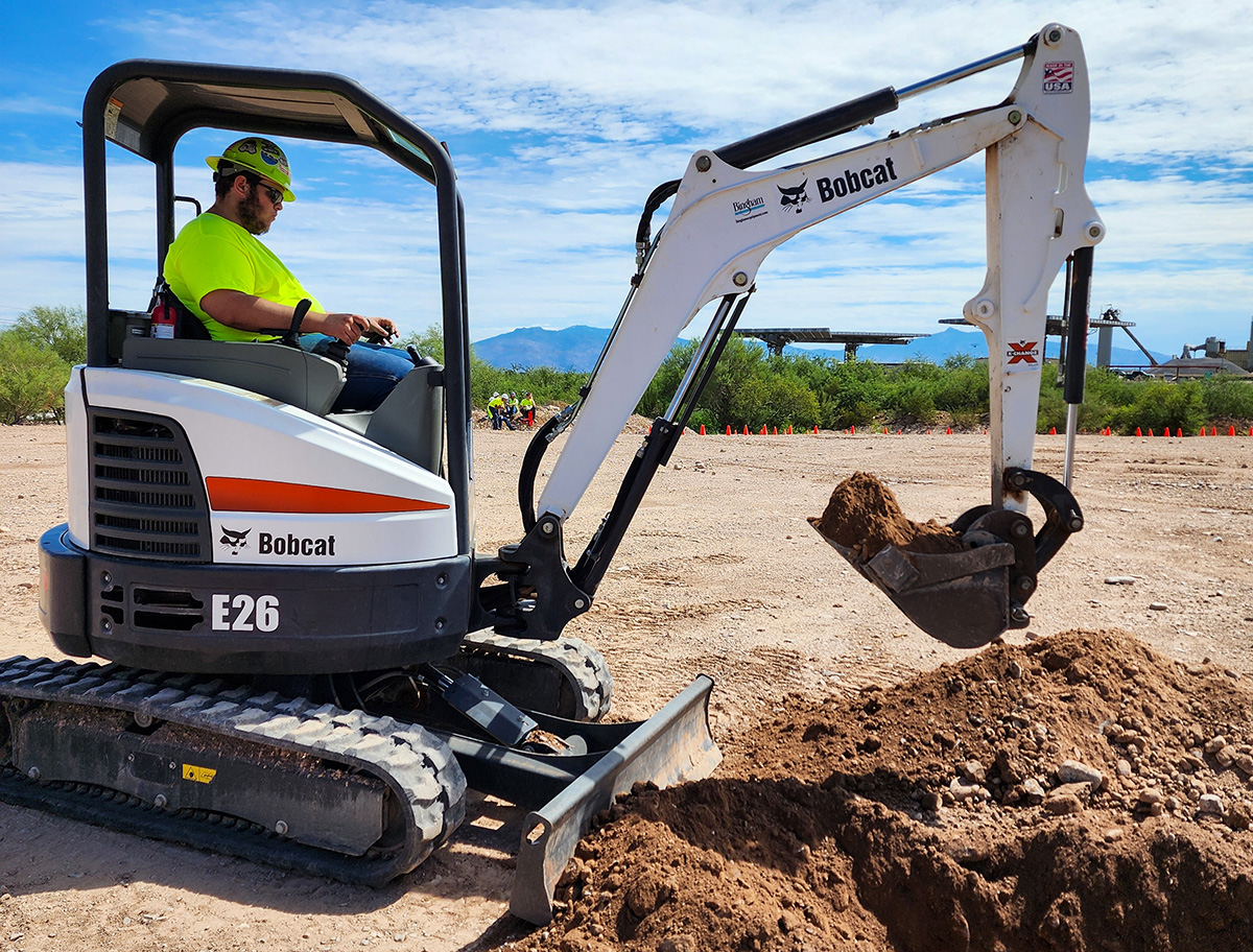 Student using mini excavator