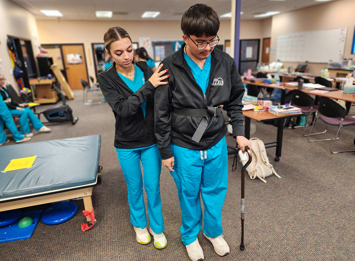 Student helping another student with cane
