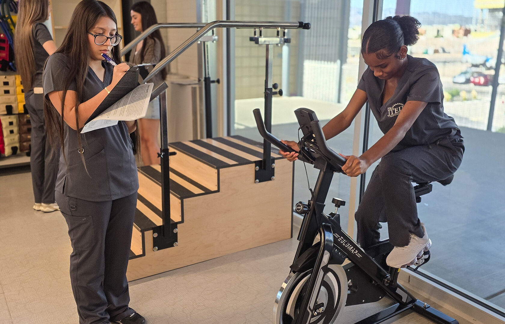 PTT Student observing patient on bike