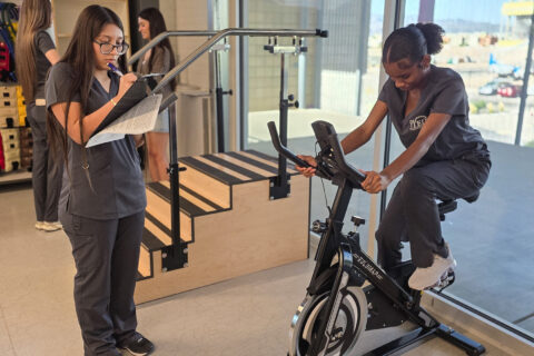 PTT Student observing patient on bike