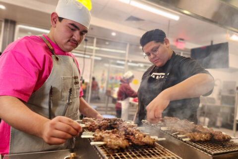 Students grilling chicken skewers