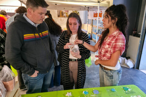 Student selling item to couple