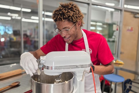 Student pouring ingredients into mixer