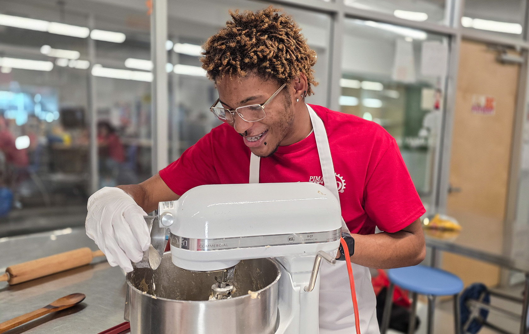 Student pouring ingredients into mixer