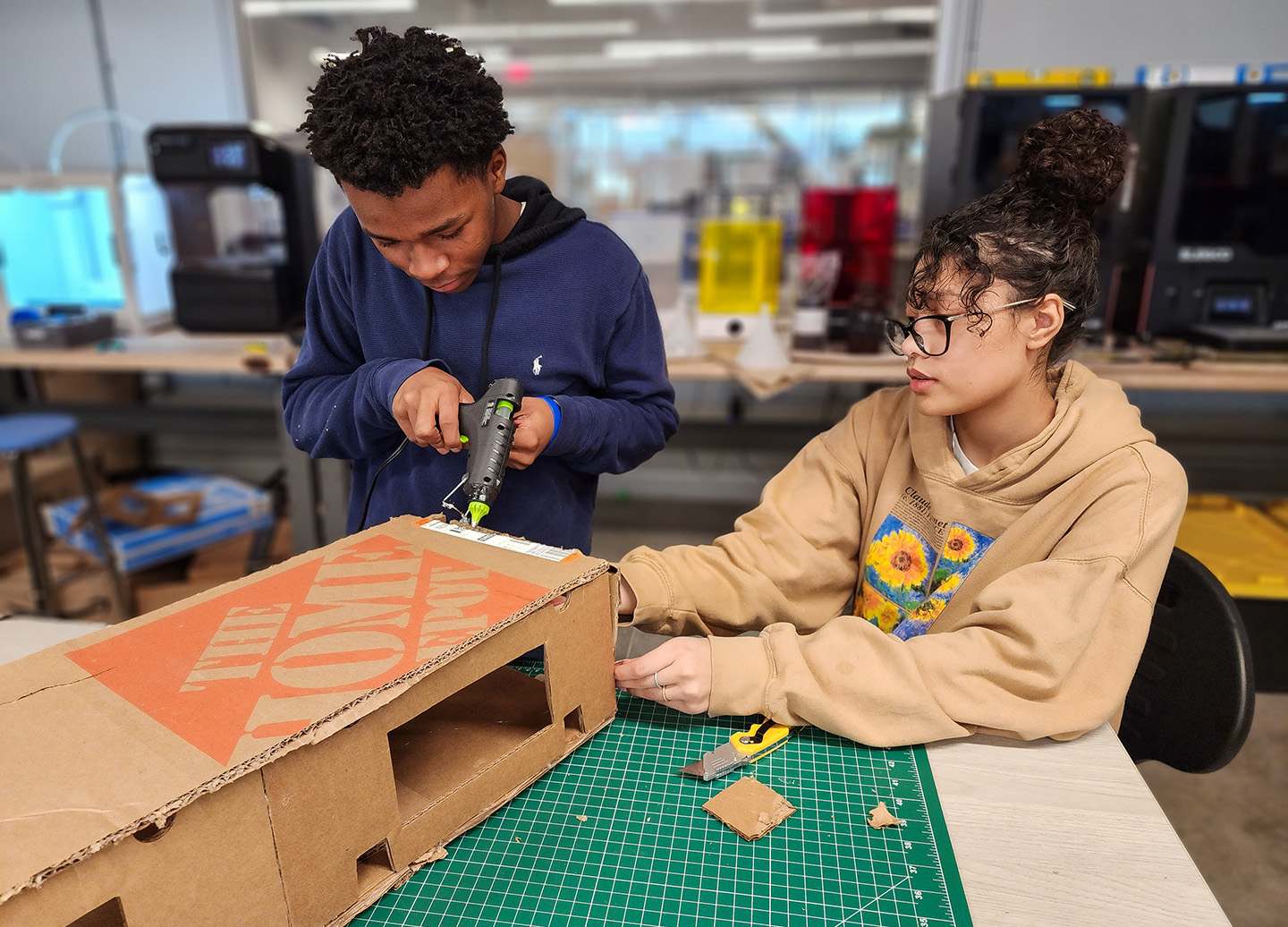 Students building cardboard bridge