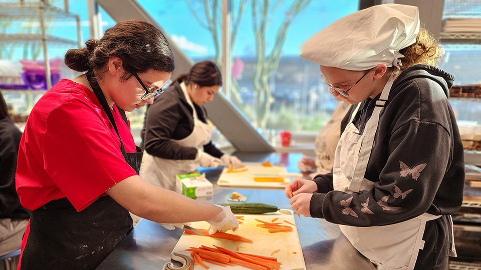 Medical Assistant and Culinary Arts Students chopping vegetables