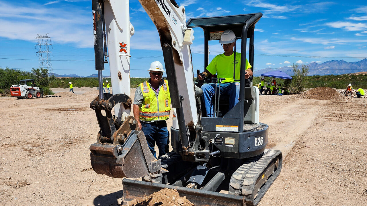 Student operating mini excavator