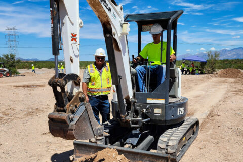 Student operating mini excavator