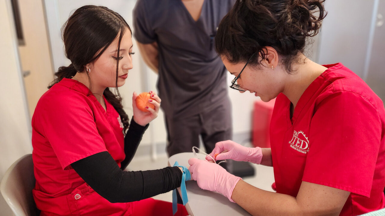 Student performing blood draw from hand