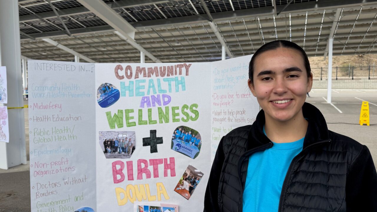 Former student with display board