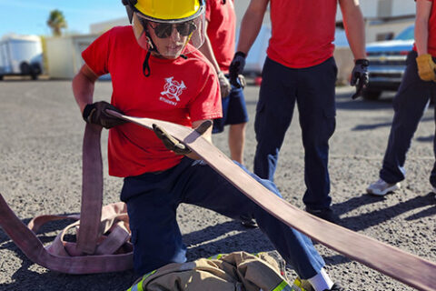 Student pulling fire hose