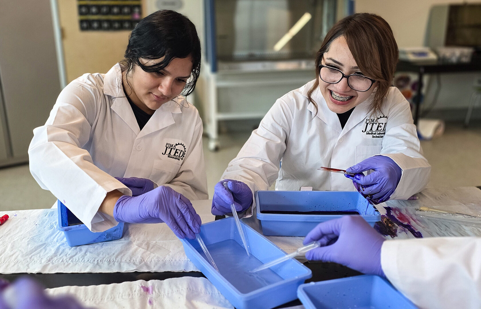 Students using pipettes to rinse off slides