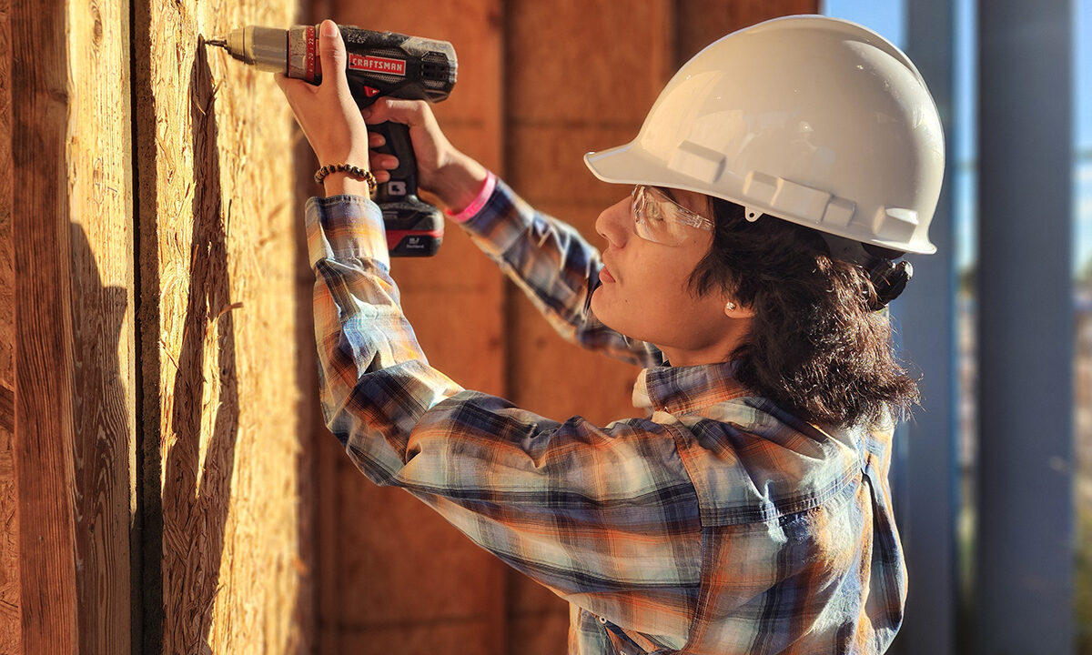 Student drilling screw into wood