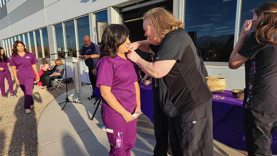 Teacher putting pin on LNA student
