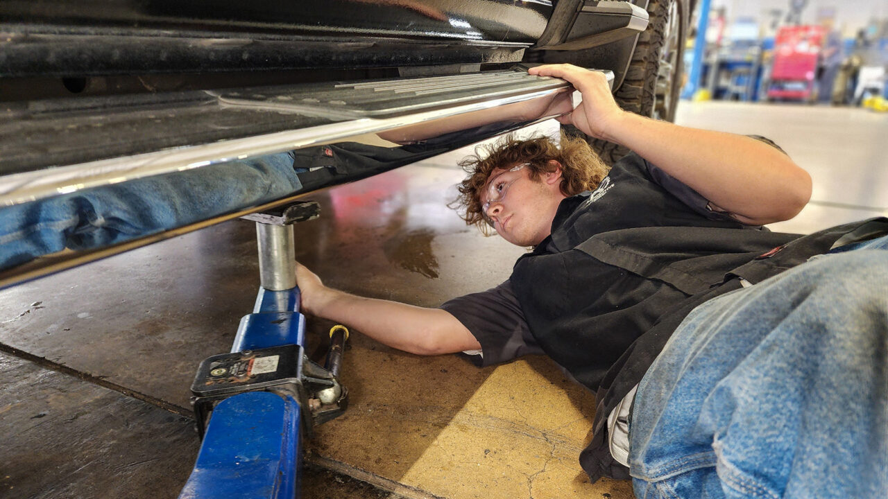 Intern placing lift under truck