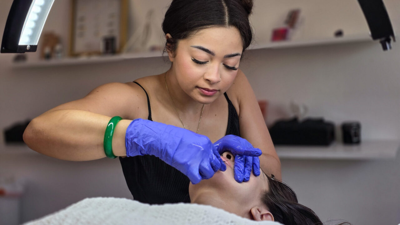 Cosmetologist performing facial scrape