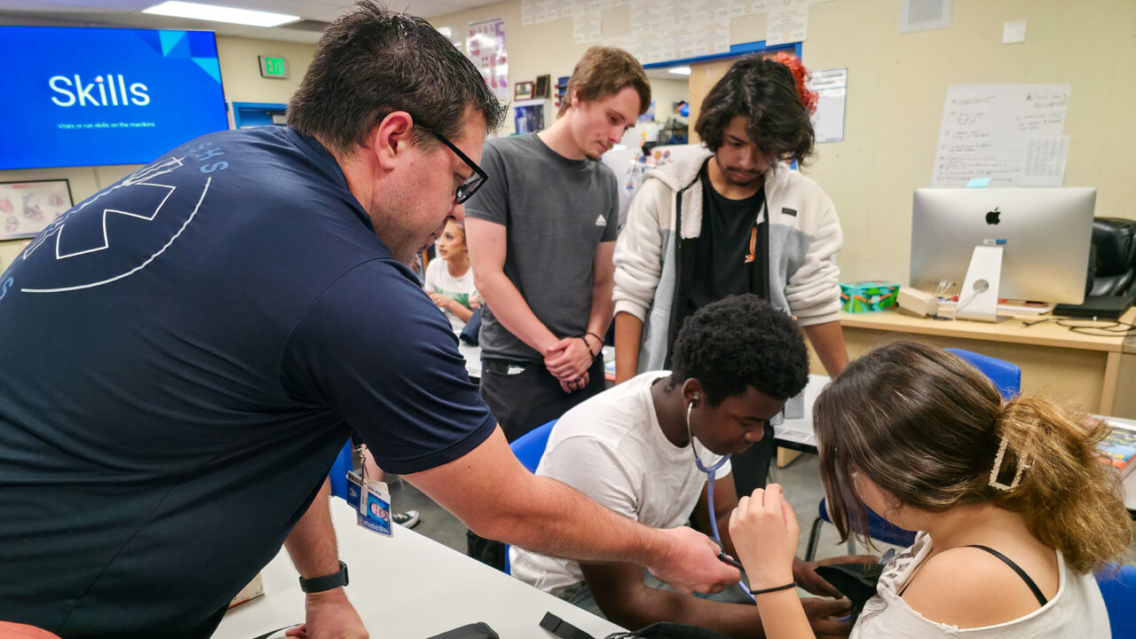 Teacher helping students take blood pressure
