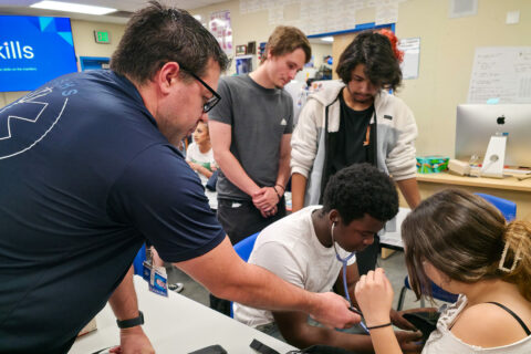 Teacher helping students take blood pressure