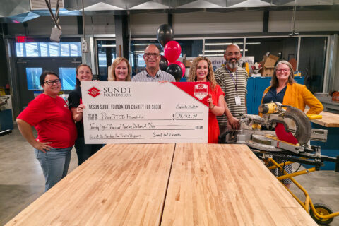 People posing with big check