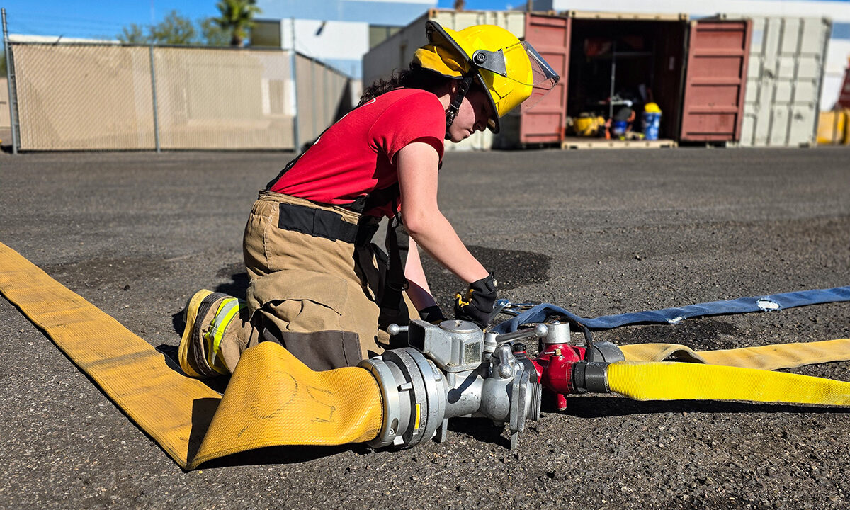 Student attaching fire hose at joint