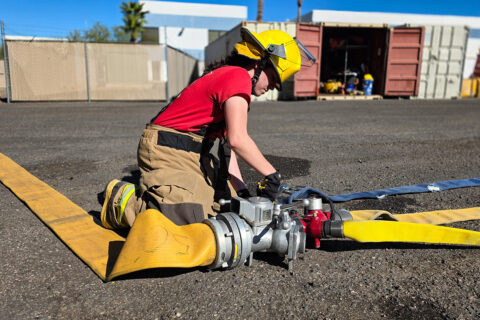 Student attaching fire hose at joint