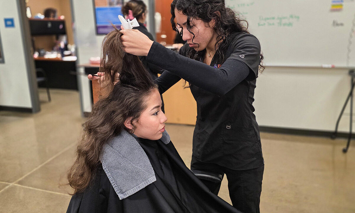 Student stylist combing hair