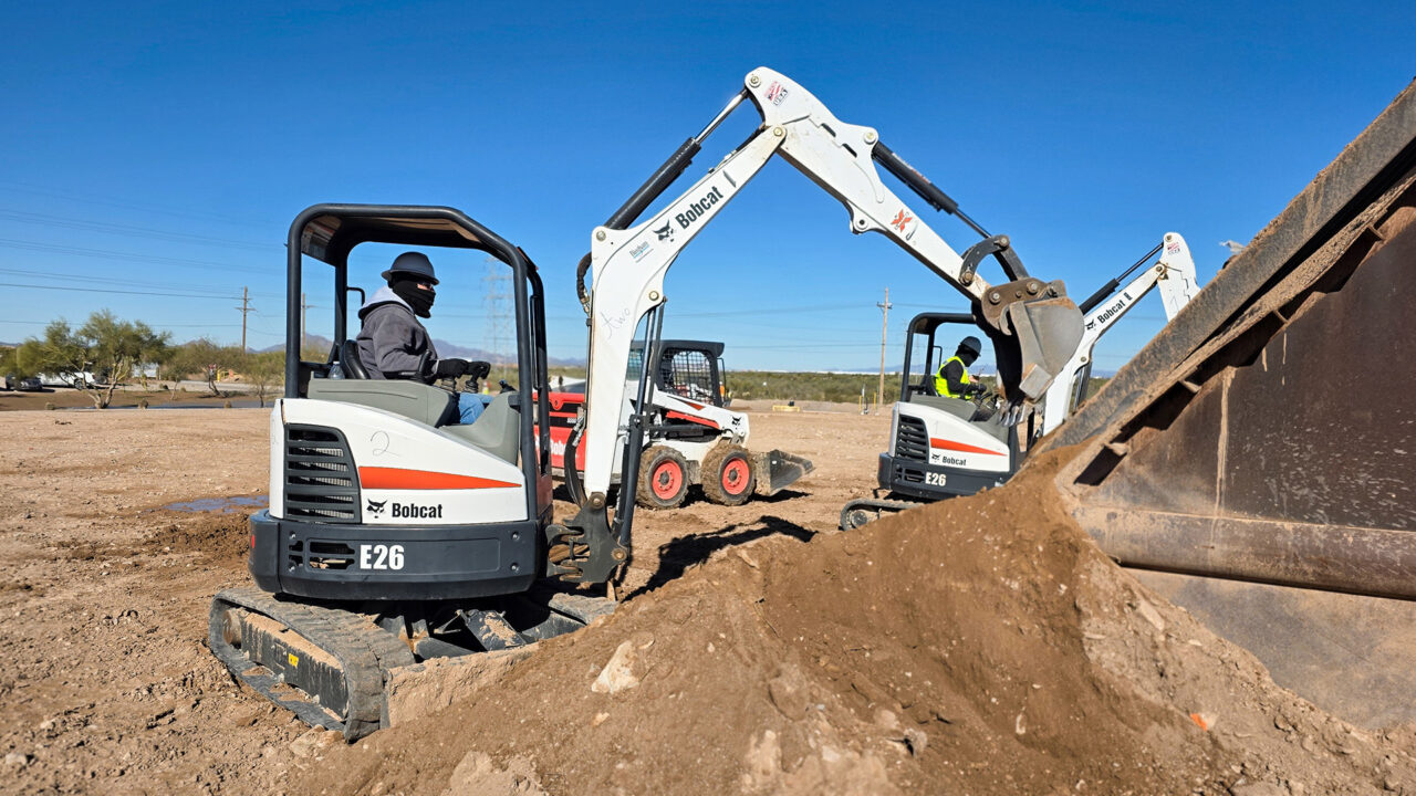 Student operating mini excavator