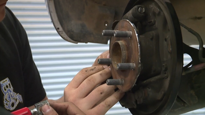 Hand working on car wheel hub