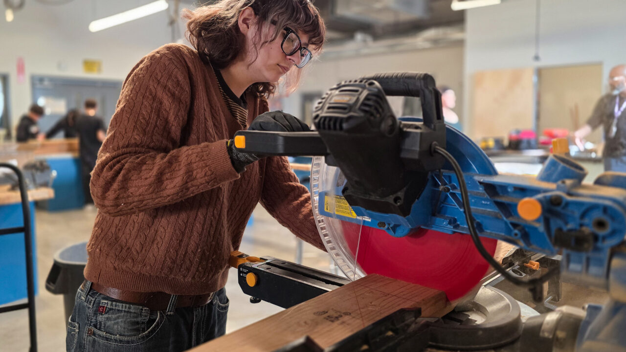 Student sawing piece of wood