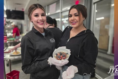 Students posing with fruit bowl