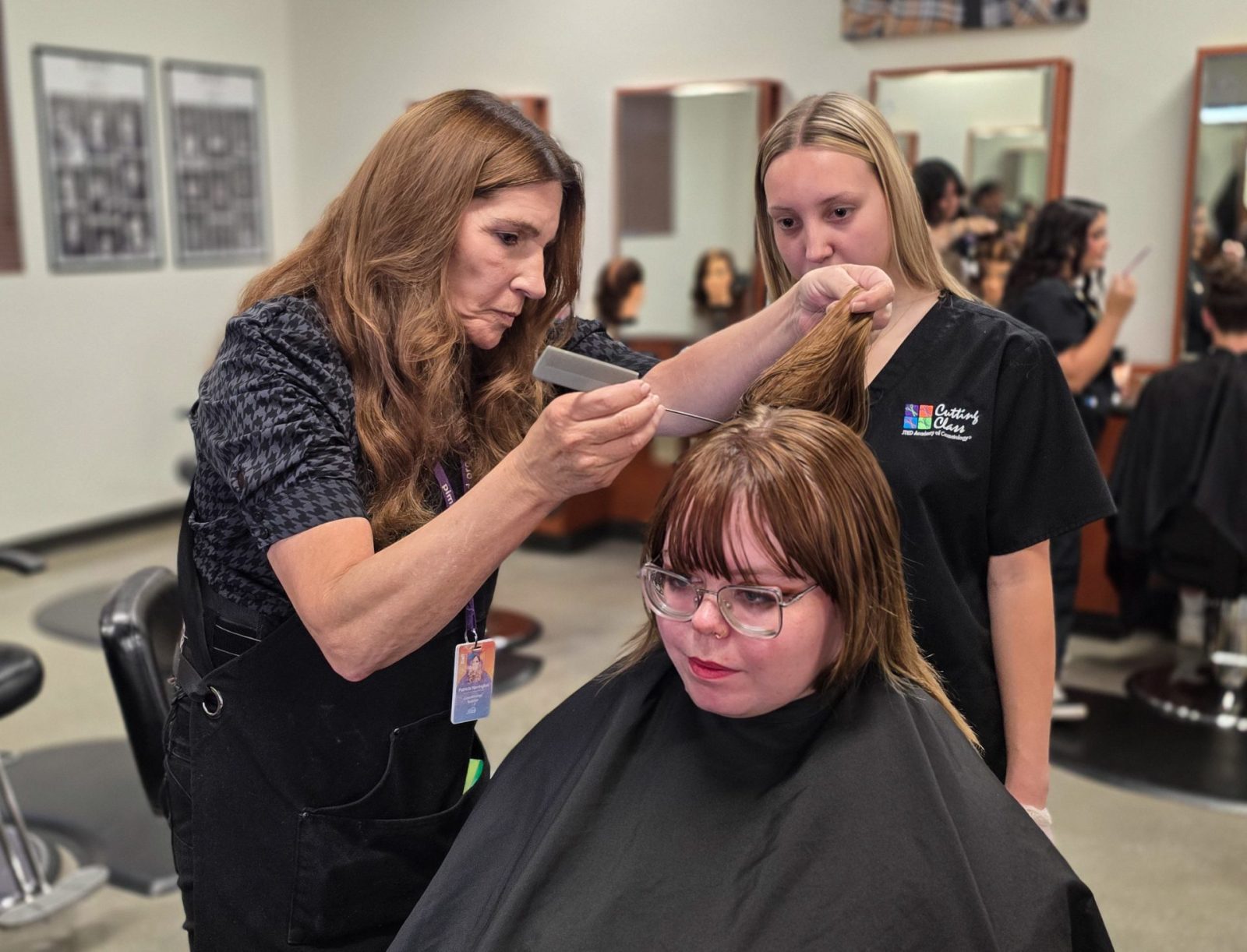 Decorative image of a Cosmetology instructor demonstrating a technique to a student