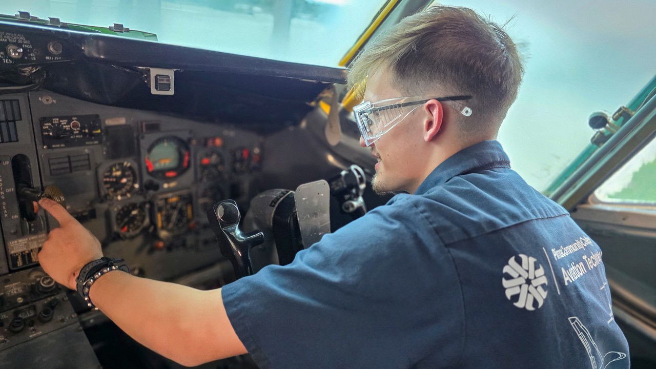 Aviation student flipping switches on control panel