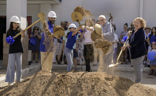 Five people shoveling dirt for ground-breaking ceremony for new childcare center in Marana